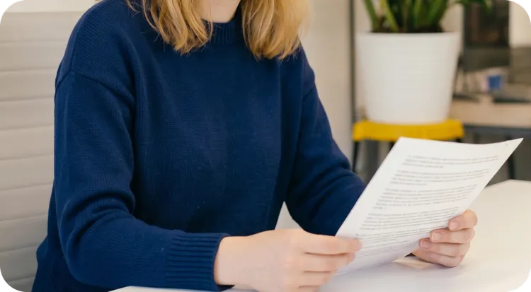 Woman holding and reading a non-disclosure agreement.