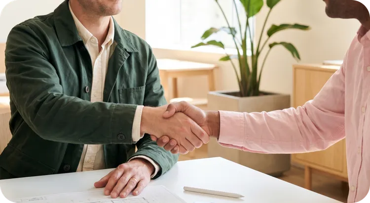 Man and woman shaking hands after signing a non-disclosure agreement.
