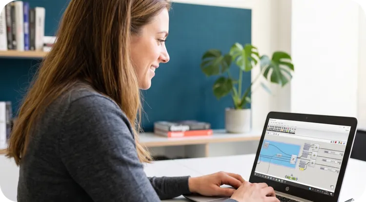 Smiling woman working on a laptop with intelligent automation software.